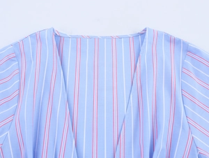 Detail of V-neck collar showing blue and white vertical stripes on the woven fabric