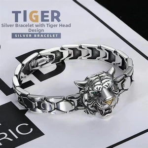 Macro detail of silver tiger head bracelet with S925 stamp and green eye accents