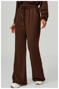 Detail of dark brown wide-leg sweatpants with drawstring waistband and ribbed texture