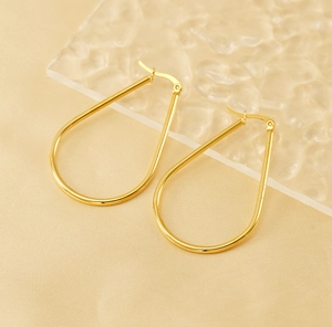 Detailed view of large gold teardrop hoop earrings with high-polish mirror finish surface