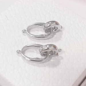 Macro view of two S925 sterling silver interlocking jewelry clasps on white leather
