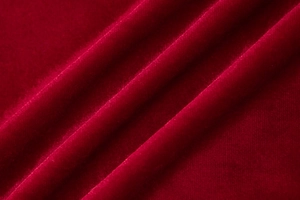 Détail du tissu en velours rouge avec plis élégants et texture douce pour robes