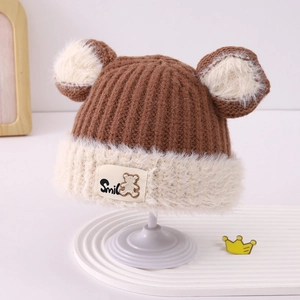 Close-up of brown knit baby hat with bear ears and Smile bear patch detail