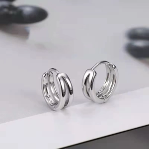 Makro-Detail der silbernen Doppelring-Creolen mit Scharnier und metallischer Textur