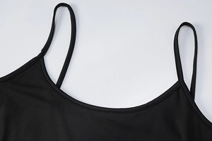Close-up of U-neckline and delicate spaghetti straps on a minimalist black backless dress