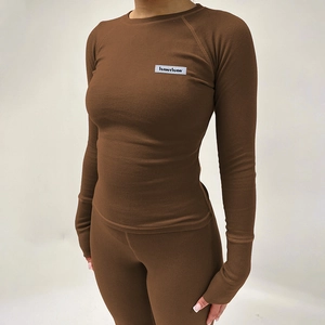 Détail d'un ensemble de yoga côtelé marron montrant les poignets et la texture du tissu
