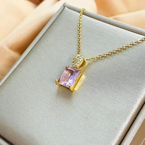 Macro di una collana dorata con pendente rettangolare in zircone rosa su seta