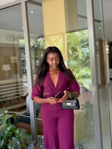 Macro shot of deep V-neckline and symmetrical side waist cut-outs on the purple jumpsuit