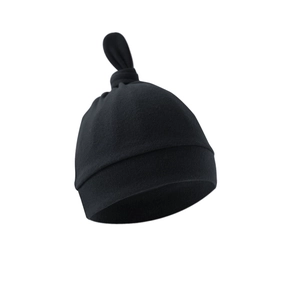 Close-up of a black cotton newborn knot hat with adjustable top and folded brim detail