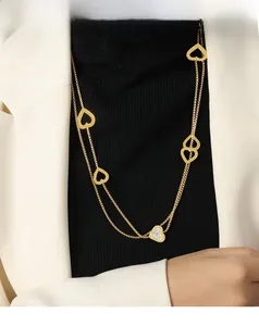 Close-up of a layered gold heart necklace featuring zircon pavé and hollow pendants