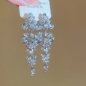 Close-up of vintage butterfly drop earrings with rhinestones on a white jewelry card