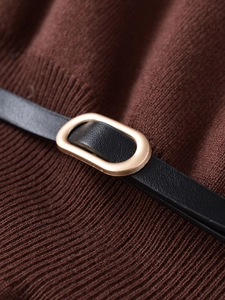 Macro detail of brown knit fabric with black leather strap and gold oval metal buckle