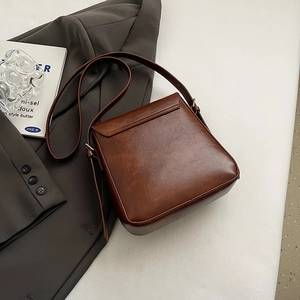 Chic brown PU leather crossbody bag with double-buckle flap design in a flat-lay stylish view