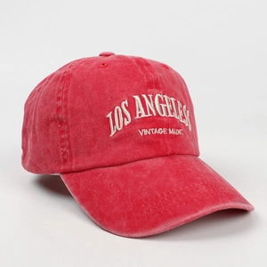 Detail of red washed cotton baseball cap featuring white Los Angeles 3D embroidery