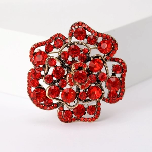Elegant 3D rose brooch in vintage gold with red sparkling rhinestones on light background
