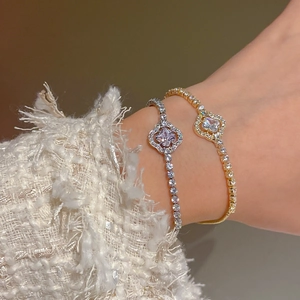 Close-up of elegant gold and silver flower bracelets with sparkling cubic zirconia inlay