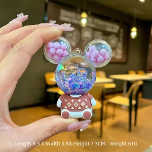 Close-up of a cartoon bear keychain with purple sequins and blue flowing sand liquid