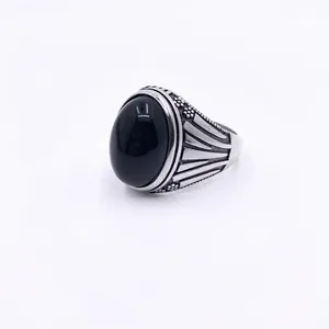 Detail of Style K vintage men's ring with black oval stone and engraved titanium steel