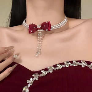 Elegant red bow choker with three-row diamond chains and pearl drop pendants on neck