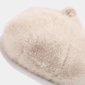 Macro detail of the soft beige faux fur texture on this winter beret hat for women
