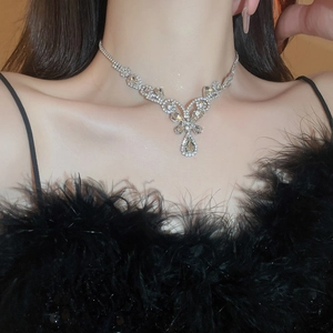 Detailed view of luxury silver floral necklace with crystal droplets on model neck