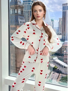 Dettaglio del pigiama da donna con motivo a cuori rossi e rifiniture di piping eleganti