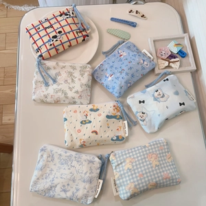 Flat lay of multiple cotton mini coin purses with cute cartoon patterns and zip closure