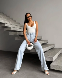 Style urbain d'un jean évasé taille haute bleu clair avec un débardeur blanc à col en V