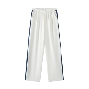 Detail of white wide-leg trousers featuring deep blue side stripes and draped fabric