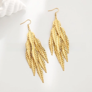 Detailed close-up of layered gold leaf tassel earrings with textured surface and fish hooks
