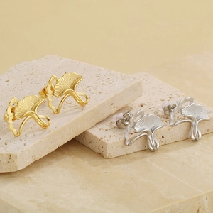 Minimalist ginkgo leaf stud earrings in gold and silver finish on textured stone