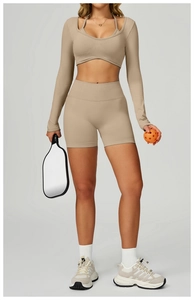 Detail of seamless two-piece long sleeve yoga crop top and shorts in light khaki