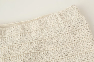Gros plan sur la taille en tricot blanc crème montrant la texture du tissu et la couture