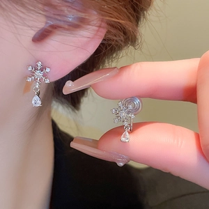 Detail of snowflake clip-on earring with sparkling zircon teardrop for non-pierced ears