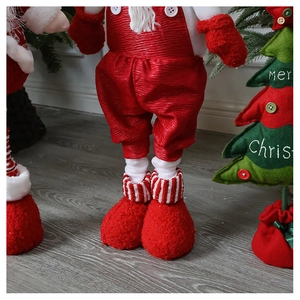 Detail of Santa figurine legs in red plush boots and striped socks on wood floor