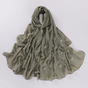 Detailed close-up of olive green chiffon hijab with pearls and floral bead embroidery