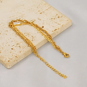 Close-up of a double-layered gold titanium steel bracelet with a rectangular zircon stone
