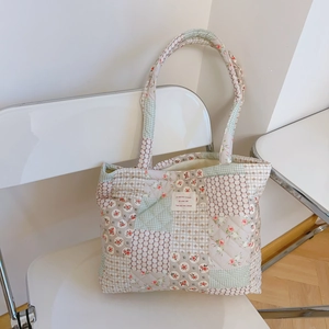 Détail d'un sac cabas en coton matelassé patchwork floral avec coutures et étiquette