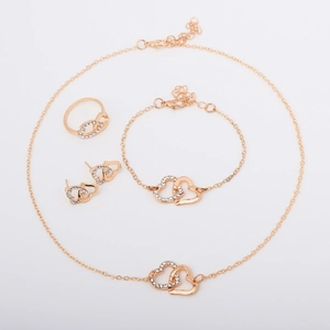 Nahaufnahme des goldenen Schmucksets mit ineinander verschlungenen Doppelherzen und Strass