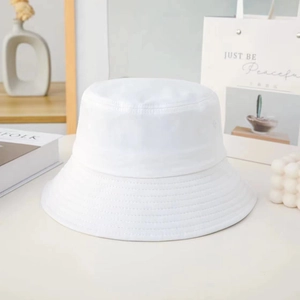 Detailed view of a white cotton bucket hat with stitching on a styled lifestyle background