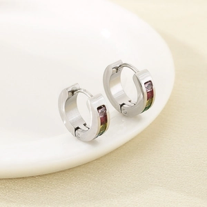 Vue détaillée de boucles d'oreilles en acier argenté avec zircons colorés sur céramique