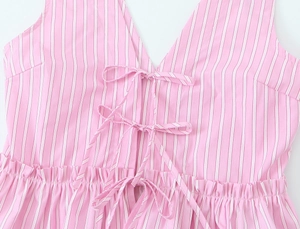 Detail of pink striped V-neck top with triple bow ties and elastic pleated waistline