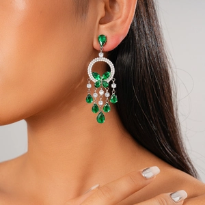 Close-up of elegant green drop tassel earrings with zircon butterfly on female model