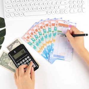 Macro detail of A6 budget planner inserts with colorful watercolor edges on desk