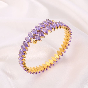 Golden titanium steel bangle featuring marquise cut purple zircons on white silk background