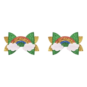 Close-up of glitter St. Patrick's Day hair bows with rainbow and cloud charms