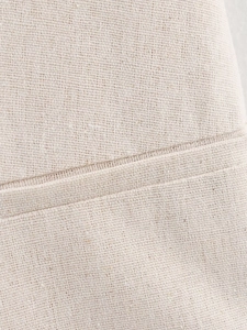 Macro view showing the natural linen blend fabric texture and stitching of the beige vest set