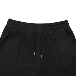 Detail of waffle knit fabric pants featuring elastic waist with drawstring and metal tips