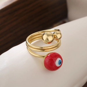 Detailed macro view of a gold-plated multi-layer evil eye ring with red and blue accents