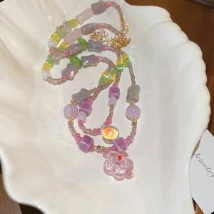 Close-up of glass flower bead necklace with pastel charms and gold lobster clasp
